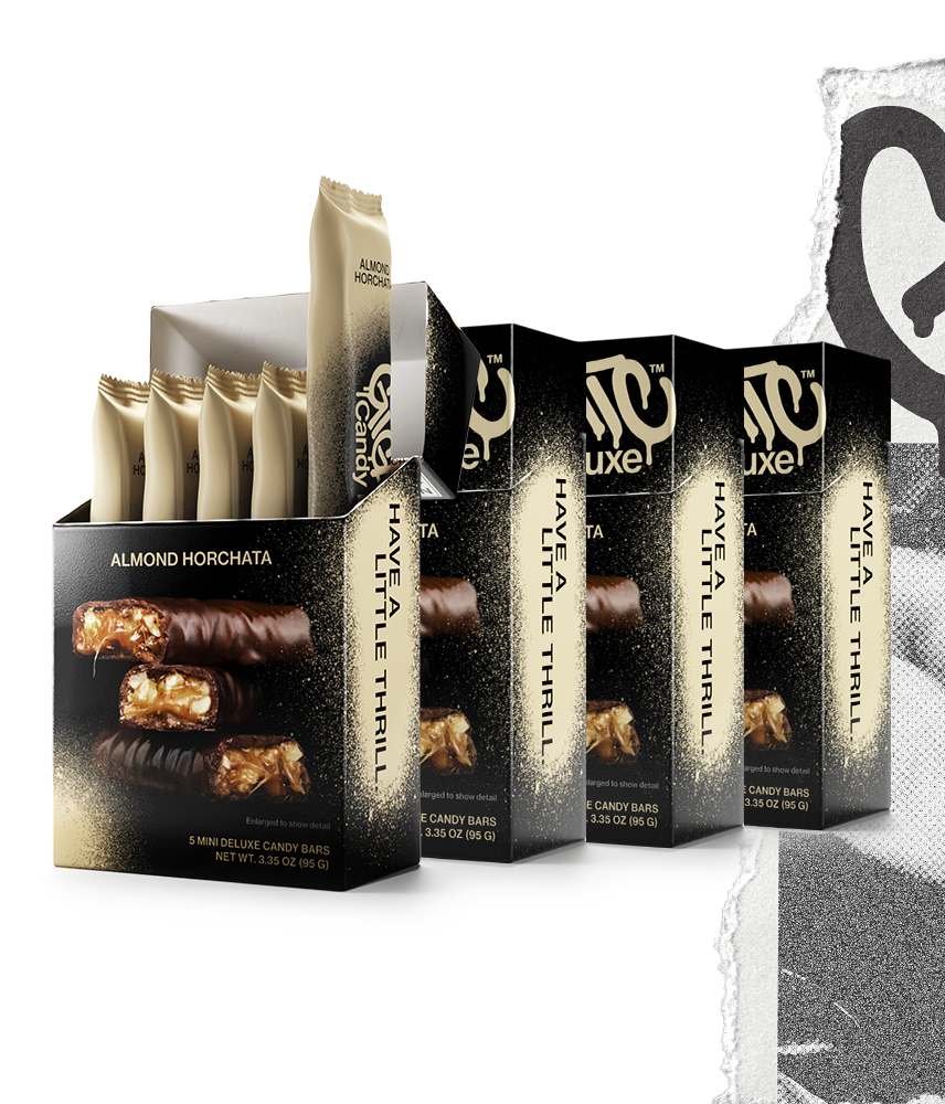 Four cartons of Gigantic Candy Deluxe in Almond Horchata flavor, tan and black colored packaging, with the front carton open to show 5 wrapped mini candy bars inside